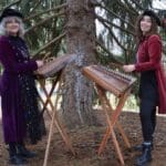 Two musicians playing hammered dulcimers outdoors